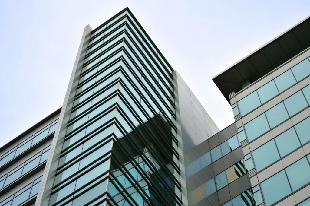 pexels-photo-164572-164572 Low angle view of a modern skyscraper with glass facade reflecting the sky.
